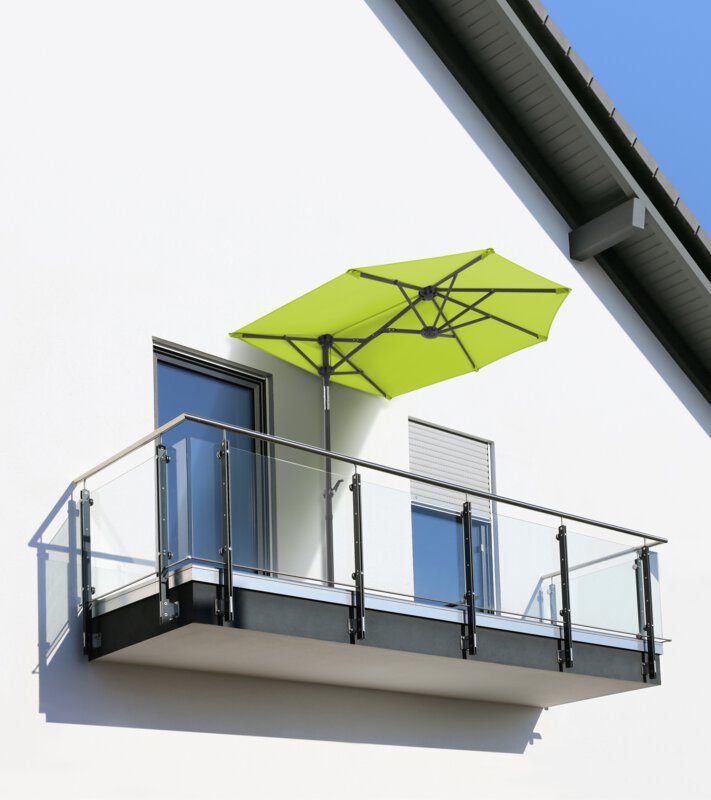 Schneider parasol Salerno mezza in apple green, 150x150 cm - the parasol stands on a small balcony with a glass railing between two windows, directly against the house wall.