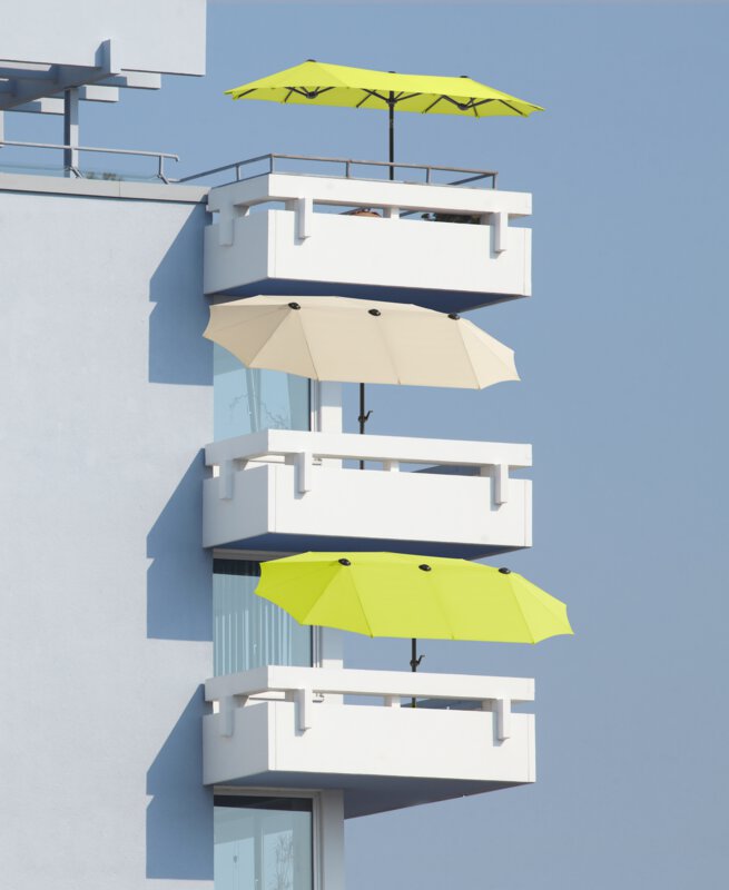 Schneider Salerno parasol in ecru and apple green, 300x150 cm - the parasols can be seen open on three balconies located one below the other.
