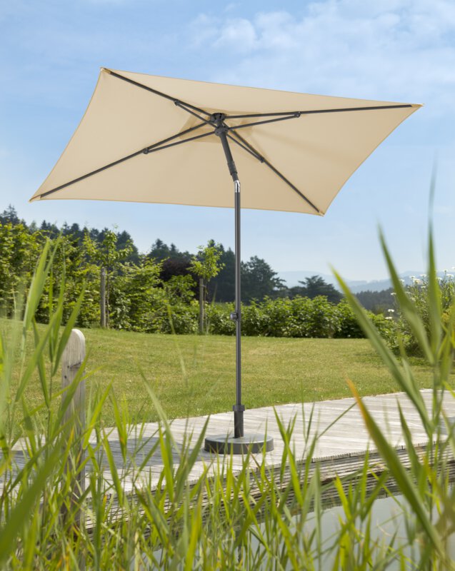 Schneider Sonnenschirm Sevilla in Natur, 240x140 cm, auf einer Holzterrasse an einem Naturpool. Im Vordergrund Schilf, im Hintergrund Wiese und verschiede Grünpflanzen.